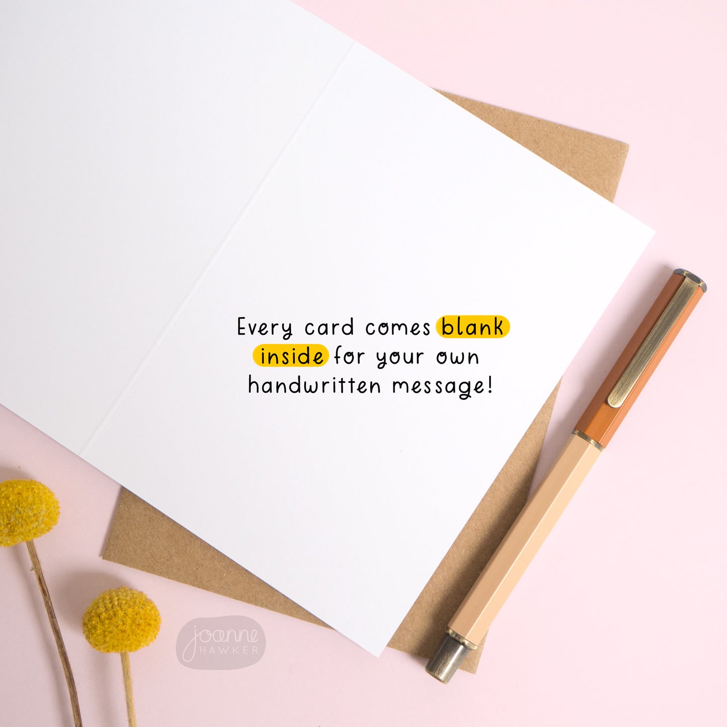  This image shows the inside of the greetings card. There is text overlaid the card reading “every card comes blank inside for your own handwritten message!” The card is open over the top of a Kraft brown envelope and photographed on a pink background.