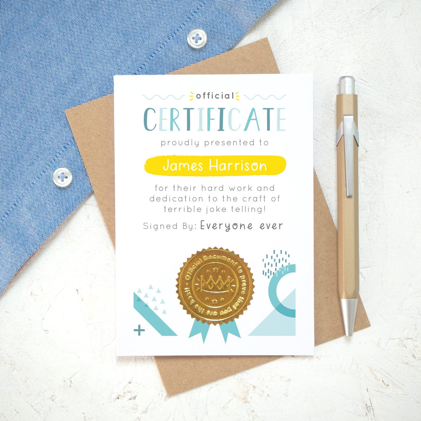 A personalised fathers day certificate printed on white card with varying tones of blue and pops of yellow and gold. Each certificate has a shiny gold seal and space to sign your name. Photographed on a white background with a blue shirt.