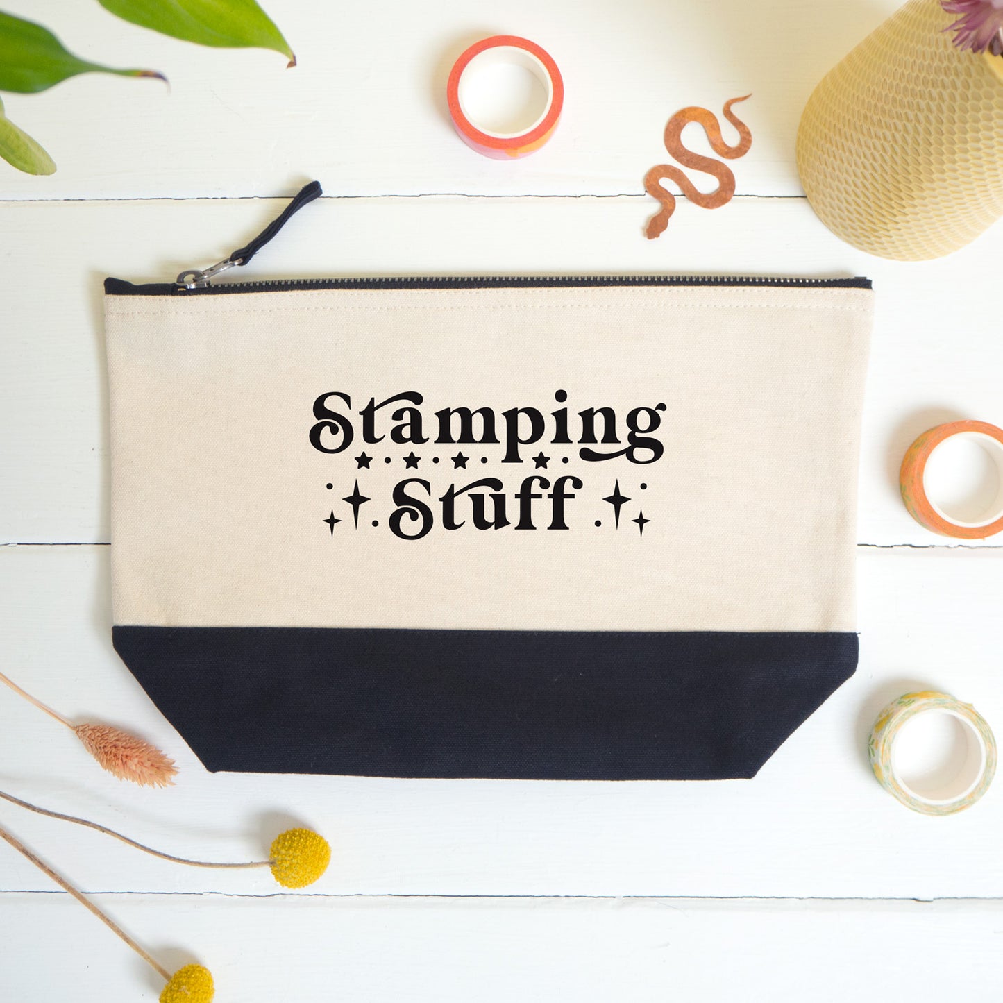 A flatlay view of the stamping stuff project bag shot on a white surface surrounded by dry flowers, washi and a snake bookmark.