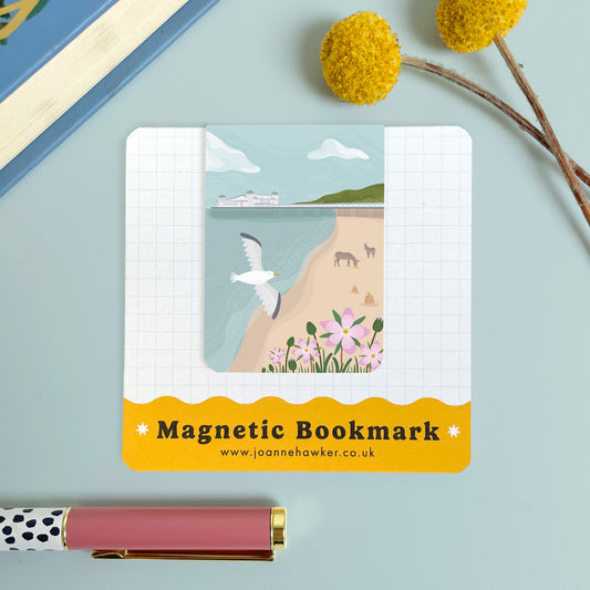 The Weston-Super-Mare magnetic bookmark on the backing card set on a blue background with yellow flowers and polka dot pen.