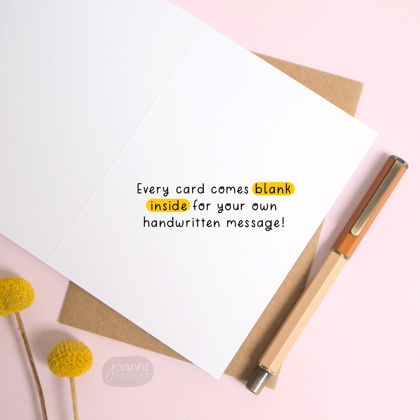 This image shows the inside of the greetings card. There is text overlaid the card reading “every card comes blank inside for your own handwritten message!” The card is open over the top of a Kraft brown envelope and photographed on a pink background.