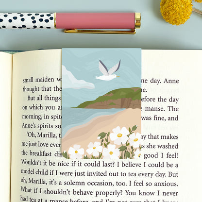 The view of the beach at Brean looking across the beach to cliffs of Brean down. This magnetic bookmark is placed on the book on top of a blue background and polka dot pen.