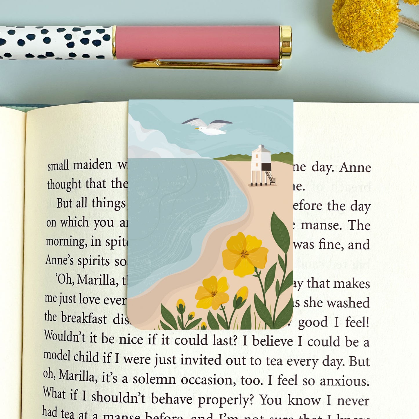 The view of the beach at Burnham on Sea looking towards the low light house. This magnetic bookmark is placed on the book on top of a blue background and polka dot pen.