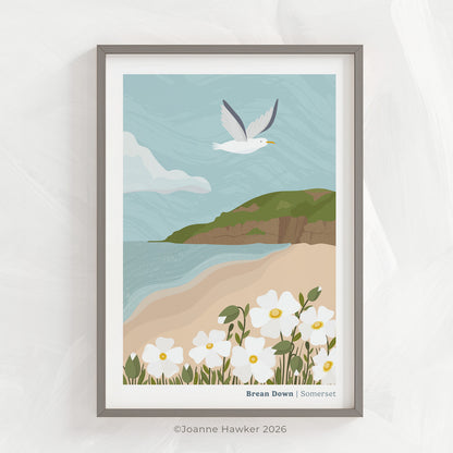 A coastal art print of the beach at Brean Down, Somerset inside of a grey picture frame set on a light grey textured background.