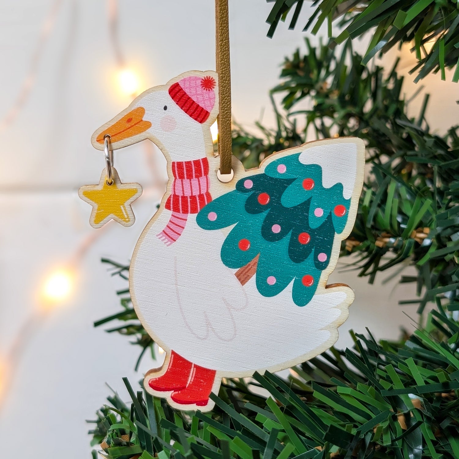 Decorative Christmas decoration of a duck with a tree on a green tree branch.