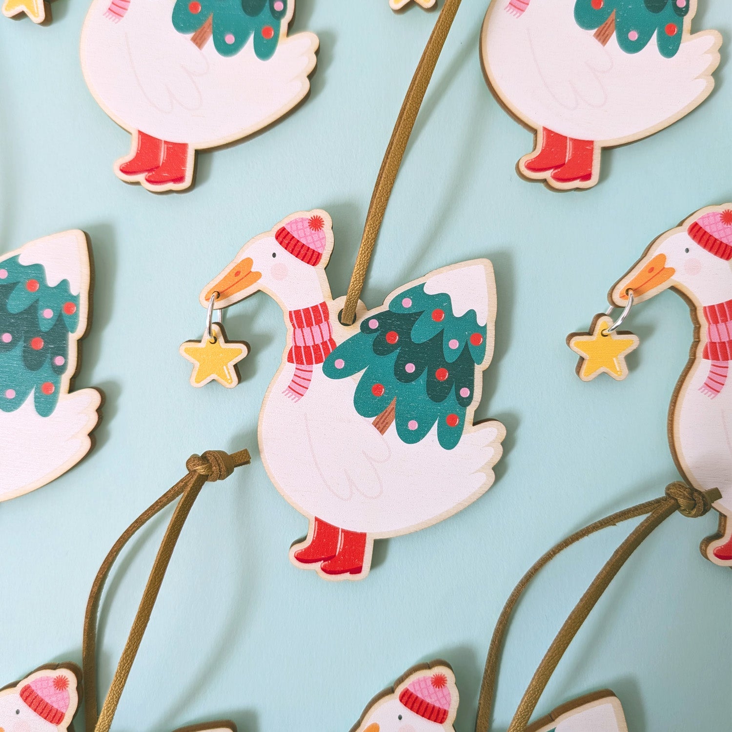 Decorative goose ornaments with Christmas trees and stars on a light blue background