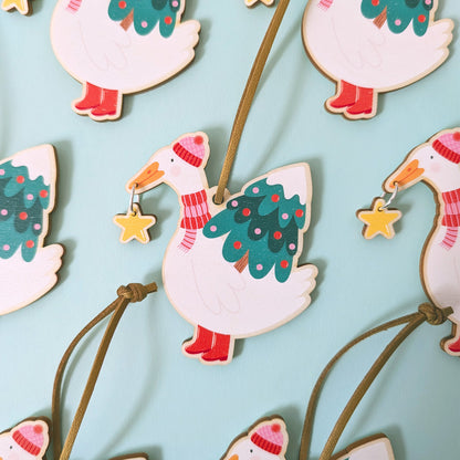Decorative goose ornaments with Christmas trees and stars on a light blue background
