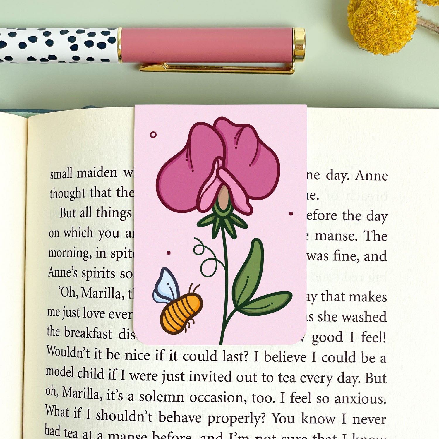 Floral pink sweet pea bookmark with a bee on an open book