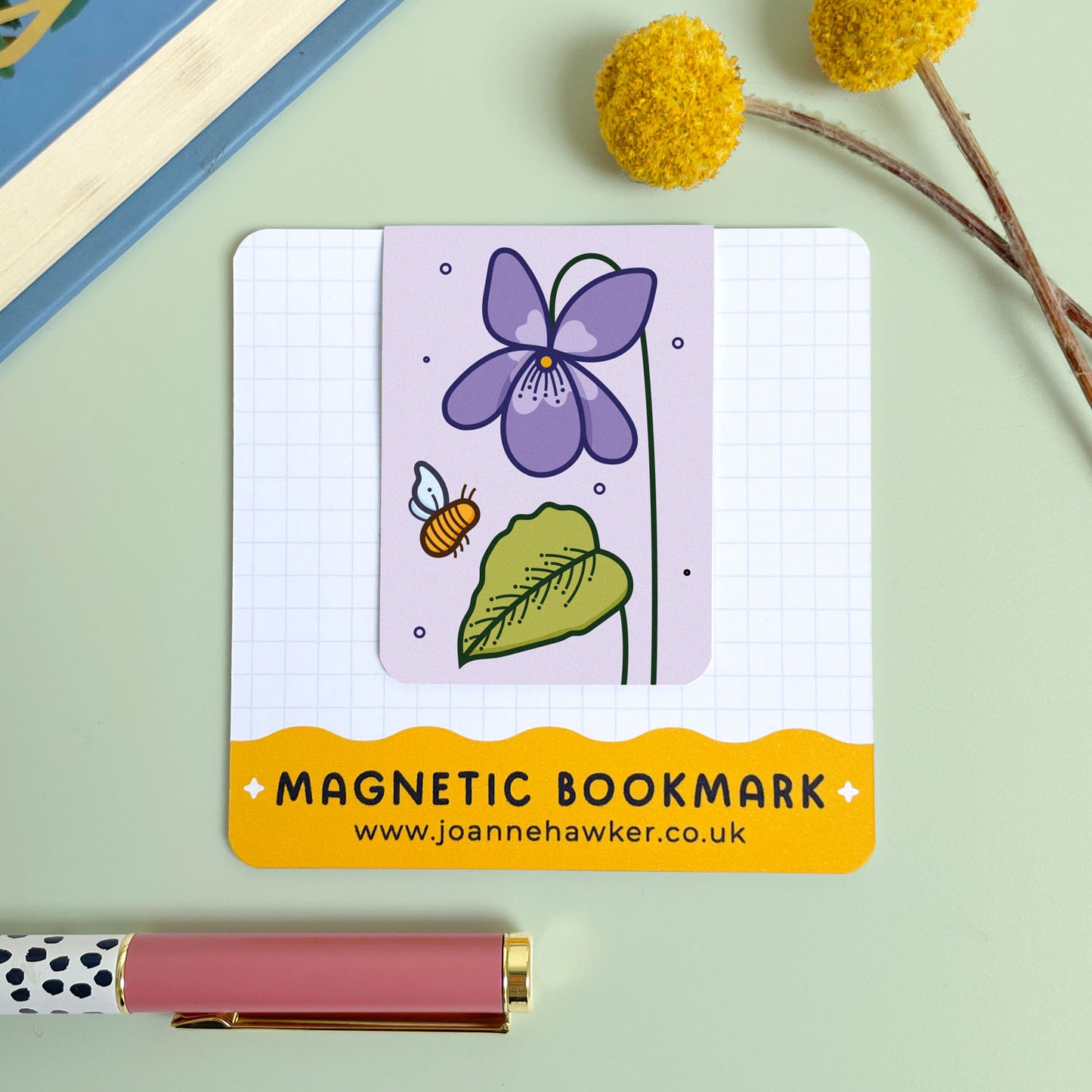 Magnetic bookmark with floral violet design on a light green background