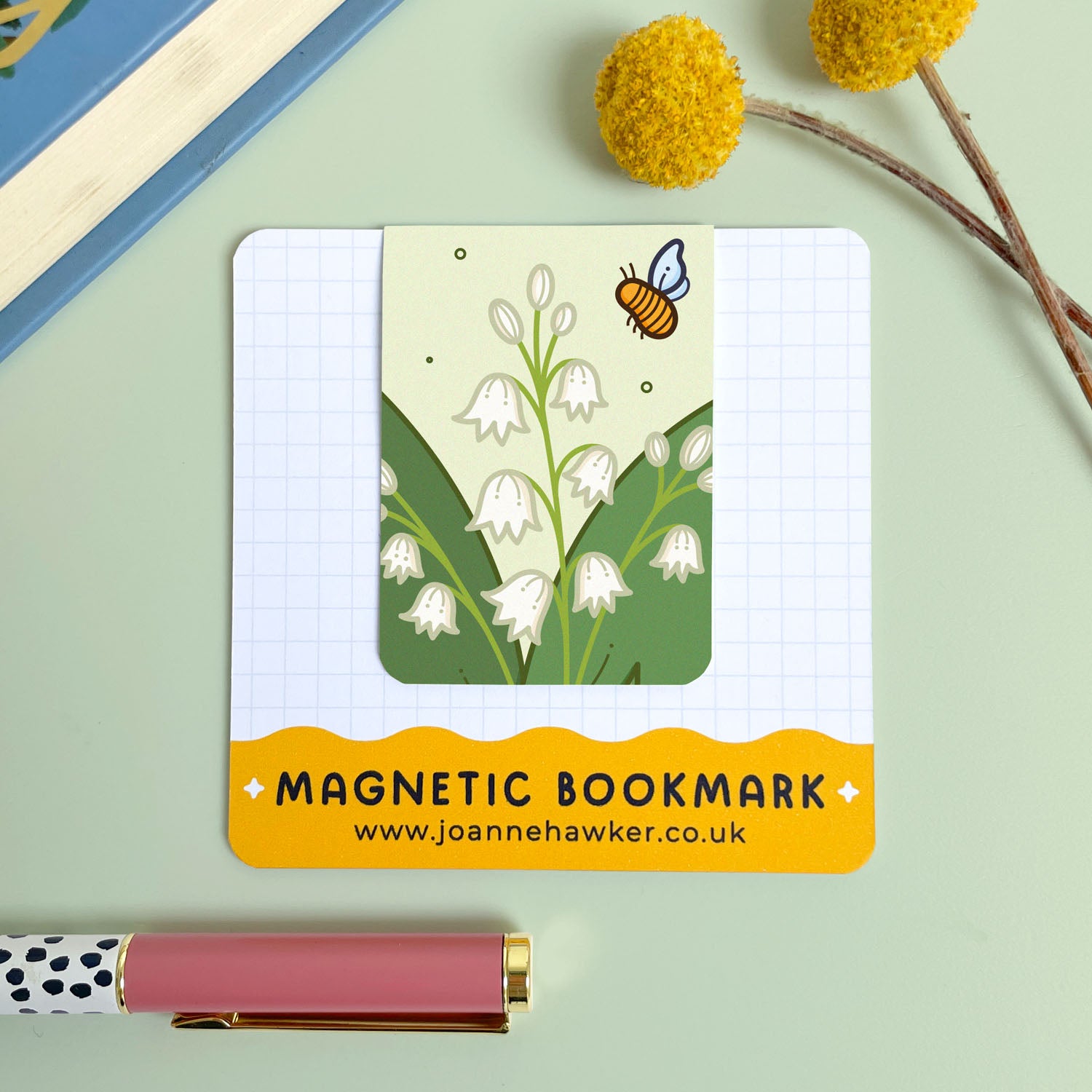 Magnetic bookmark with floral lily of the valley design and bee illustration on a light green background