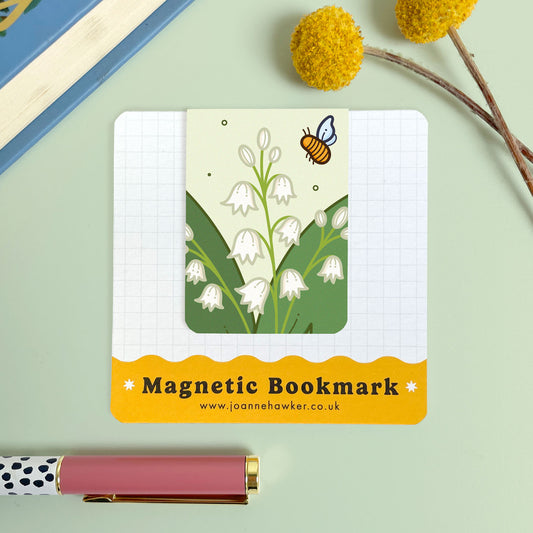 Magnetic bookmark with floral lily of the valley design and bee illustration on a light green background