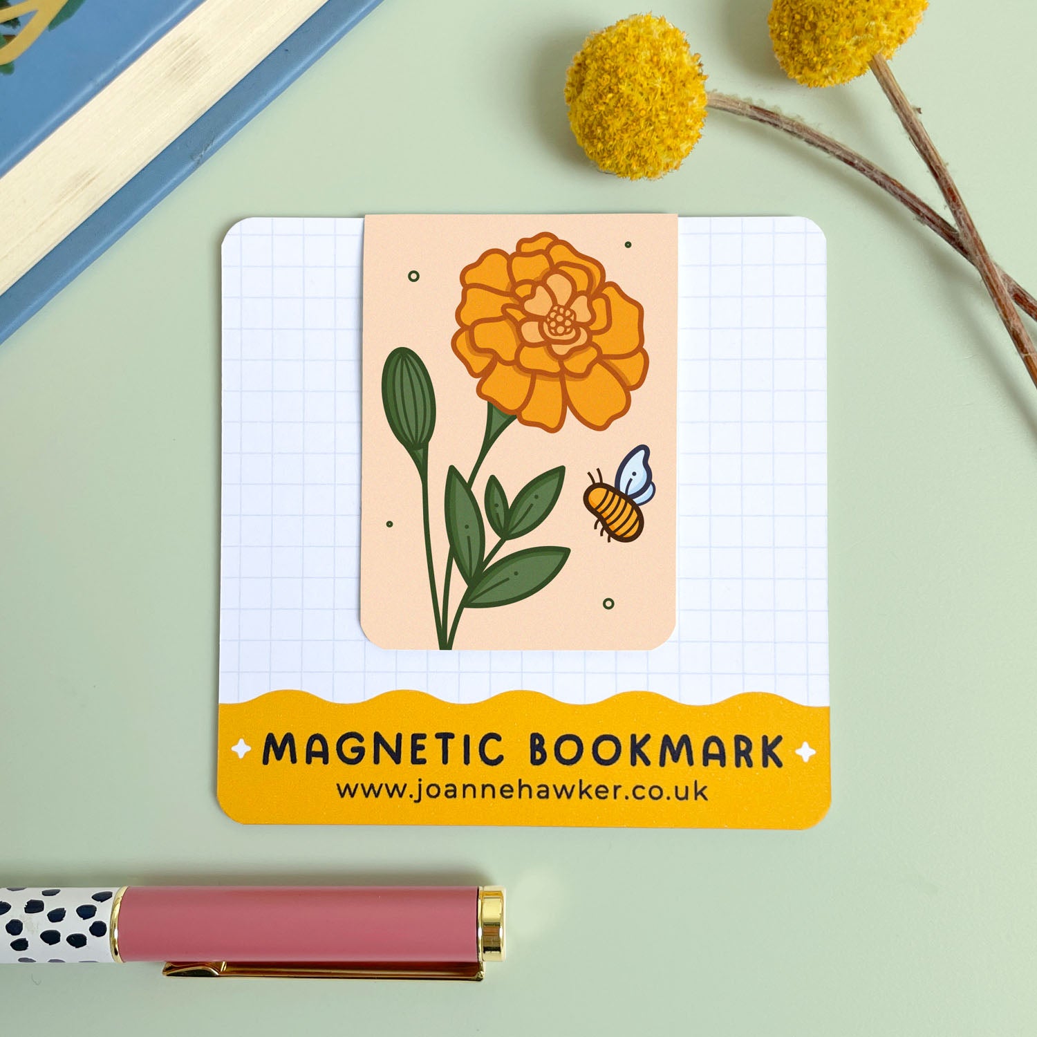 Magnetic bookmark with floral marigold design and bee illustration on a light green background