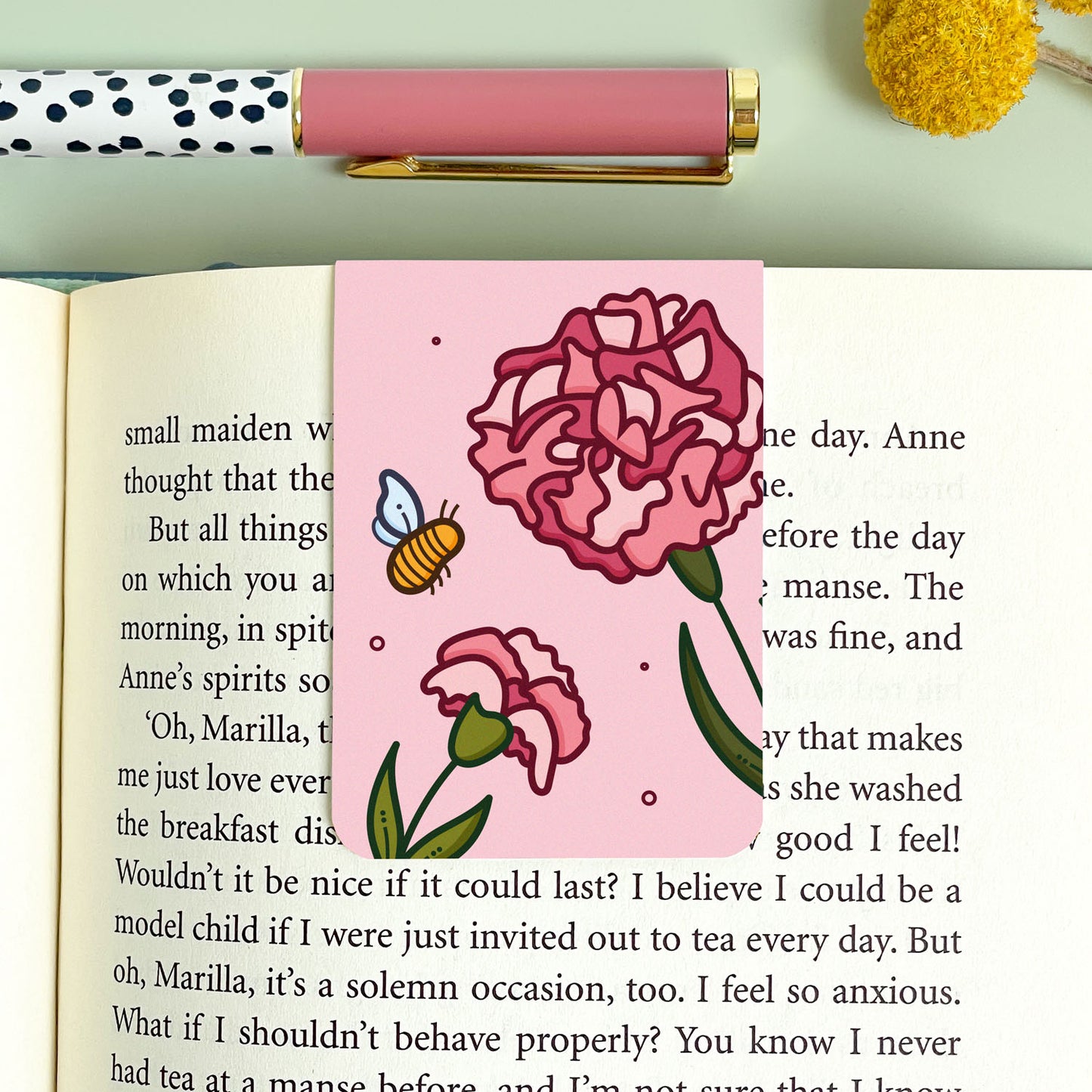 Floral carnation bookmark with pink flowers and a bee on an open book