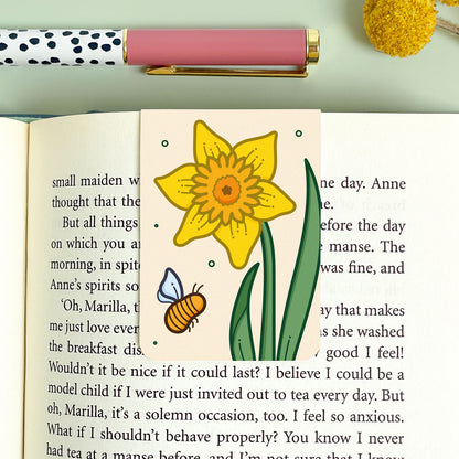Bookmark with a yellow daffodil flower illustration and a pink pen on a green background
