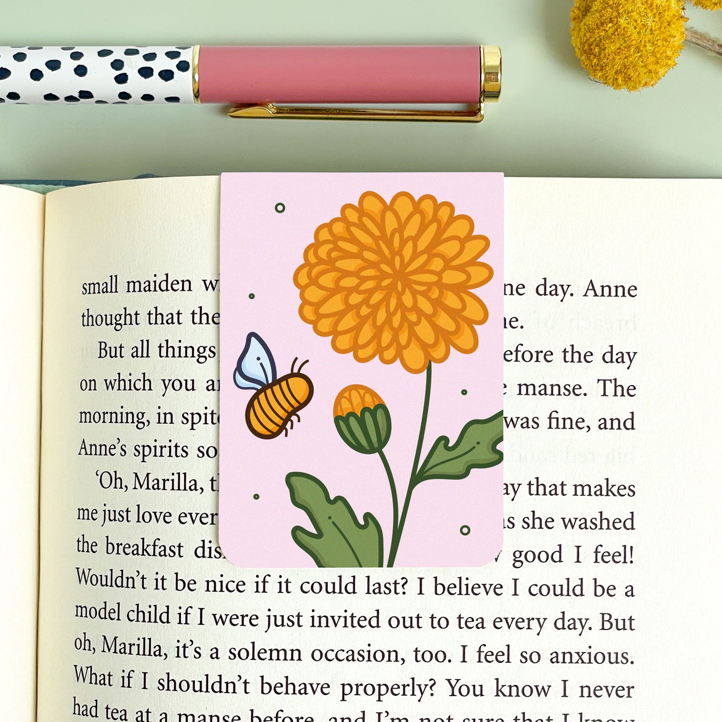 Floral chrysanthemum bookmark with a bee design on an open book