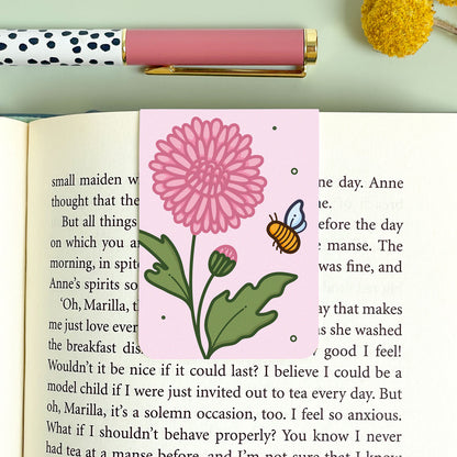 Floral chrysanthemum bookmark on an open book with a pen and decorative elements.