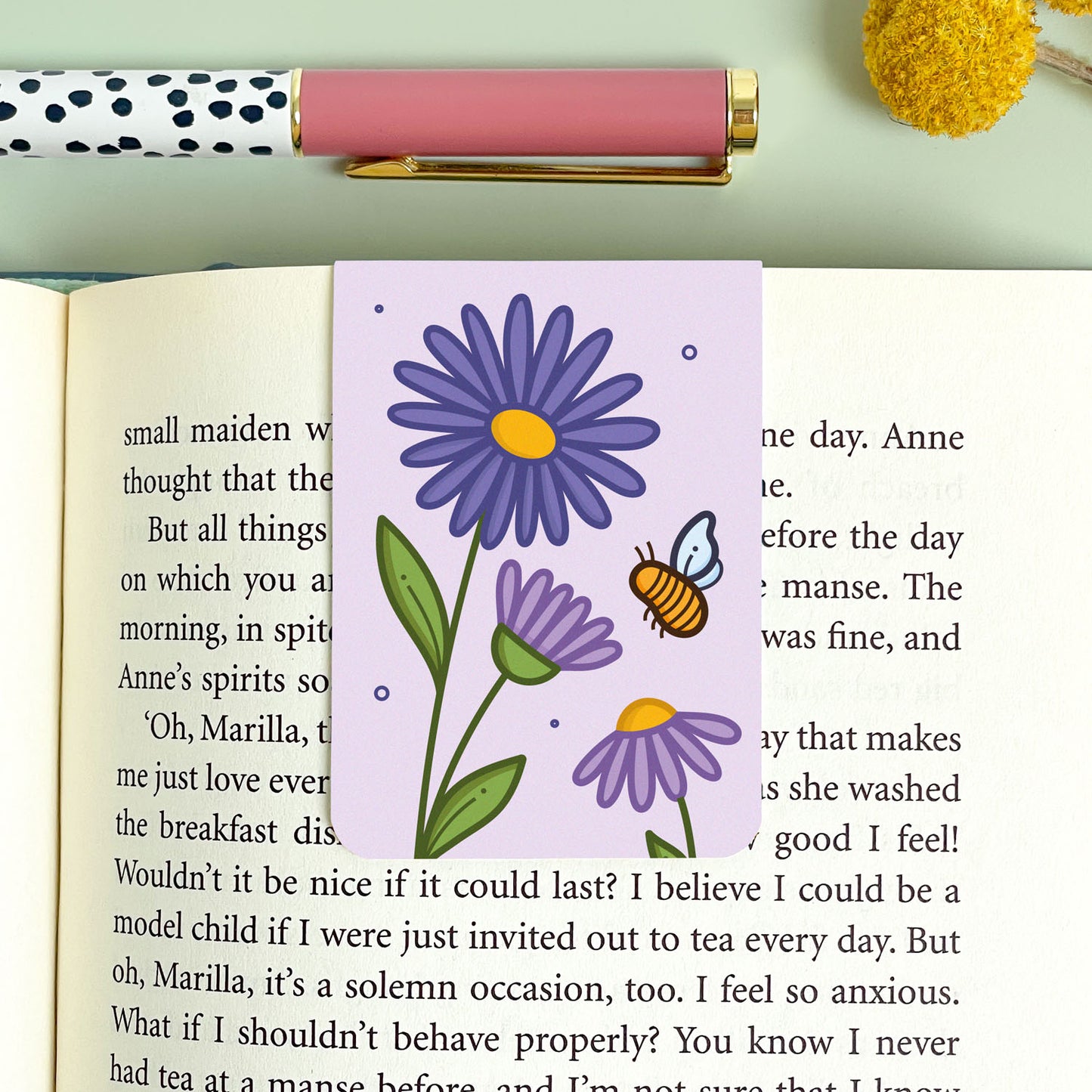 Floral aster bookmark with a bee on an open book