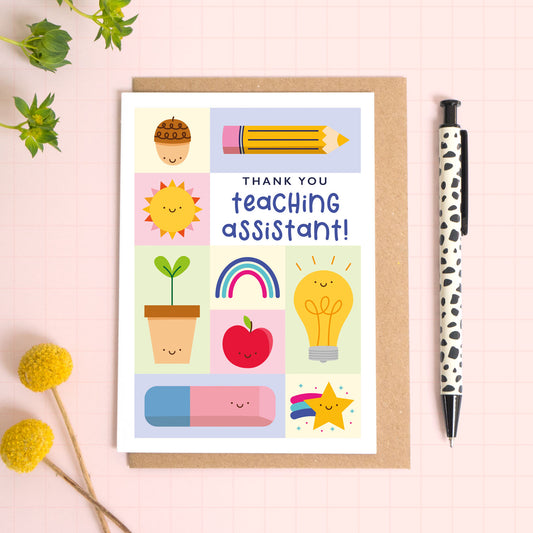 Thank you teaching assistant card with a kraft brown envelope. This teaching assistant thank you card features a variety of happy school related objects including an acorn, pencil, growing seed, apple and an eraser. The perfect card for primary school teaching assistants.