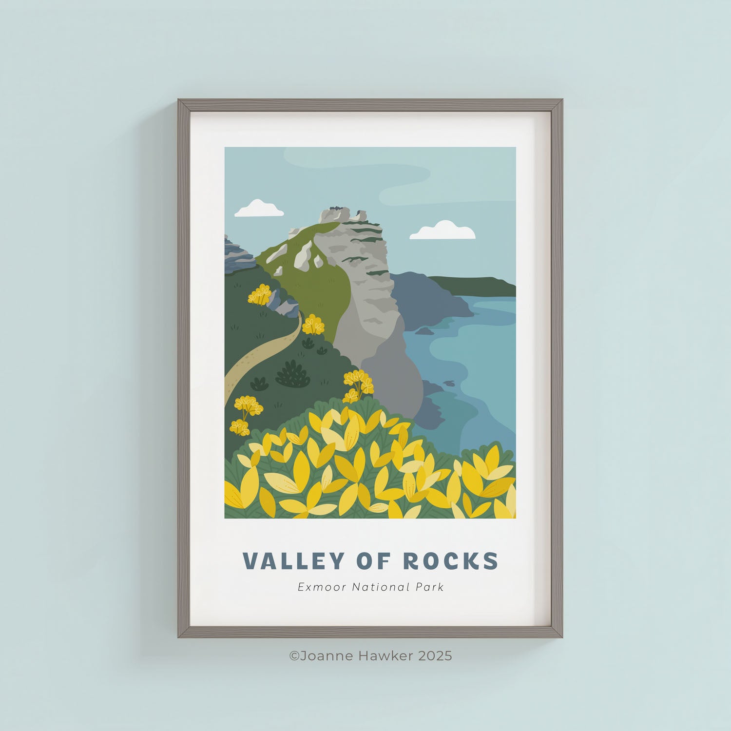 Framed, illustrated A4 print of Valley of Rocks in Exmoor National Park on a light blue wall.