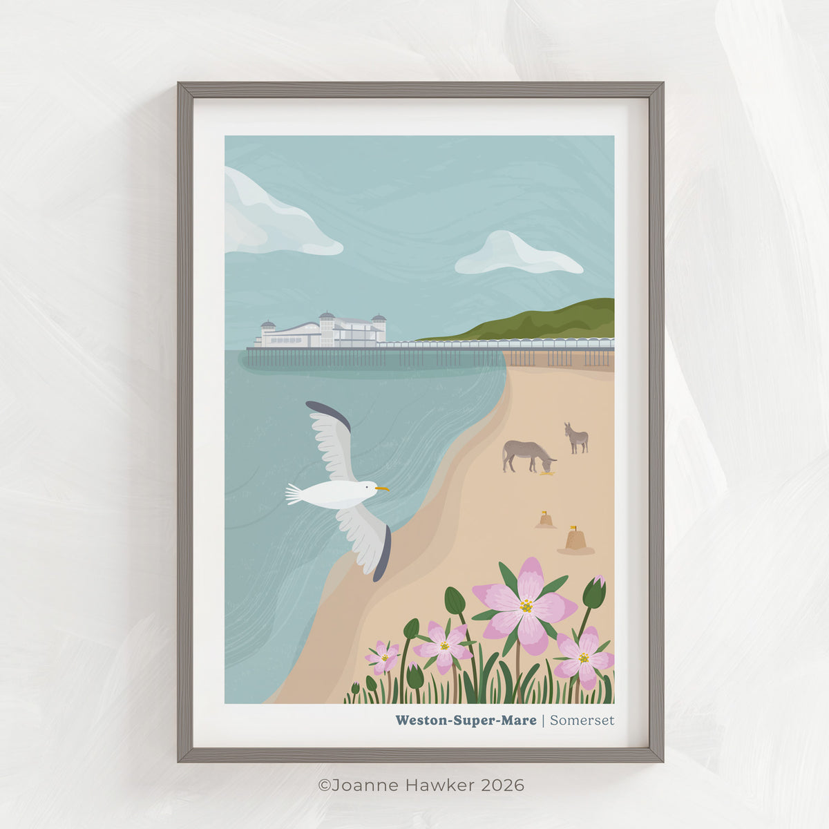 A coastal art print of the seafront at Weston-Super-Mare featuring the pier and famous Weston Donkeys inside of a grey picture frame set on a light grey textured background.