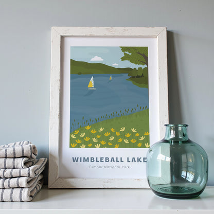 Wimbleball Lake, Exmoor National Park art print in a white frame on a light grey background with a pile of cloths and blue vase.