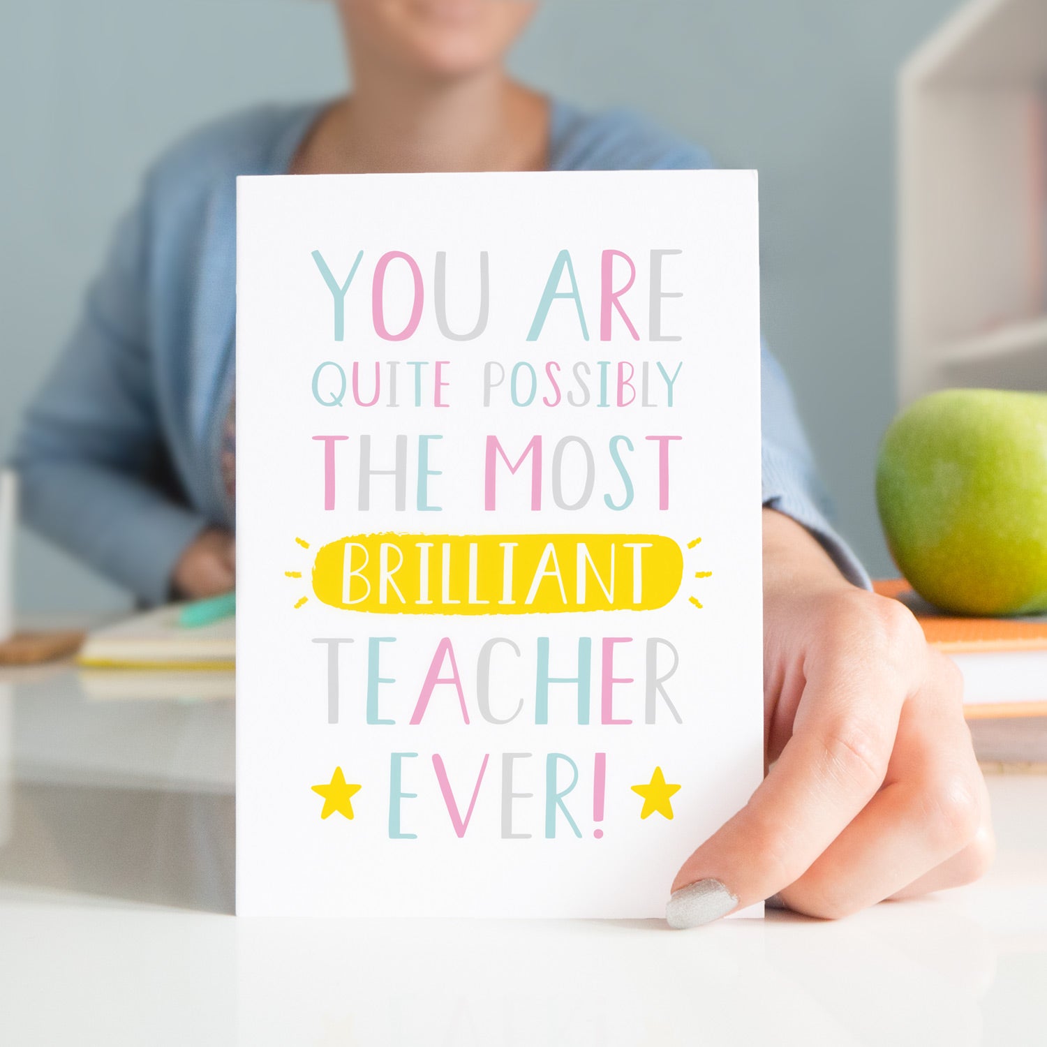 A thank you teacher card that reads "You are quite possibly the most brilliant teacher ever!" with pink, blue and grey typography with a burst of yellow!