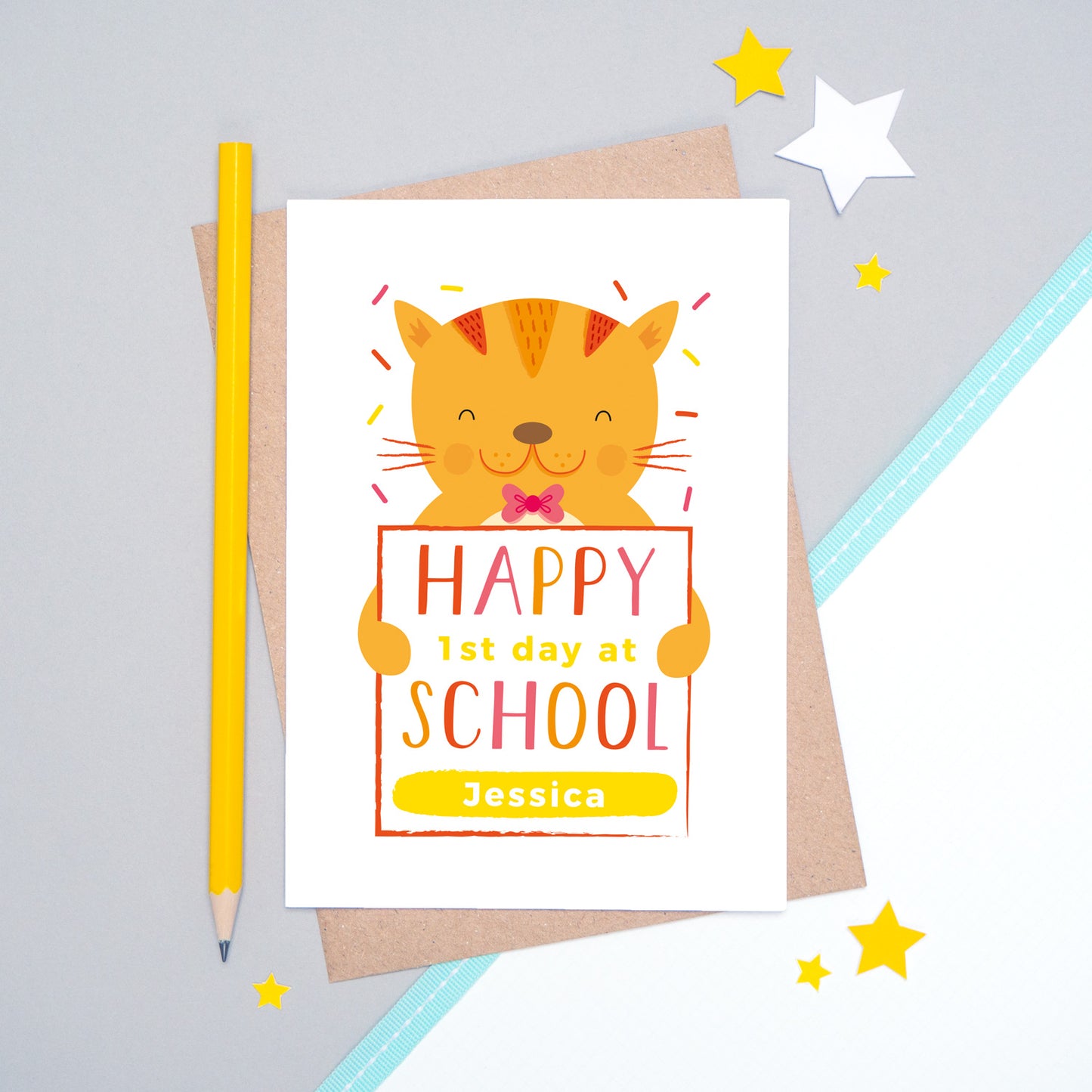 A happy 1st day at school personalised card featuring a friendly orange cat sat on a grey and white background.