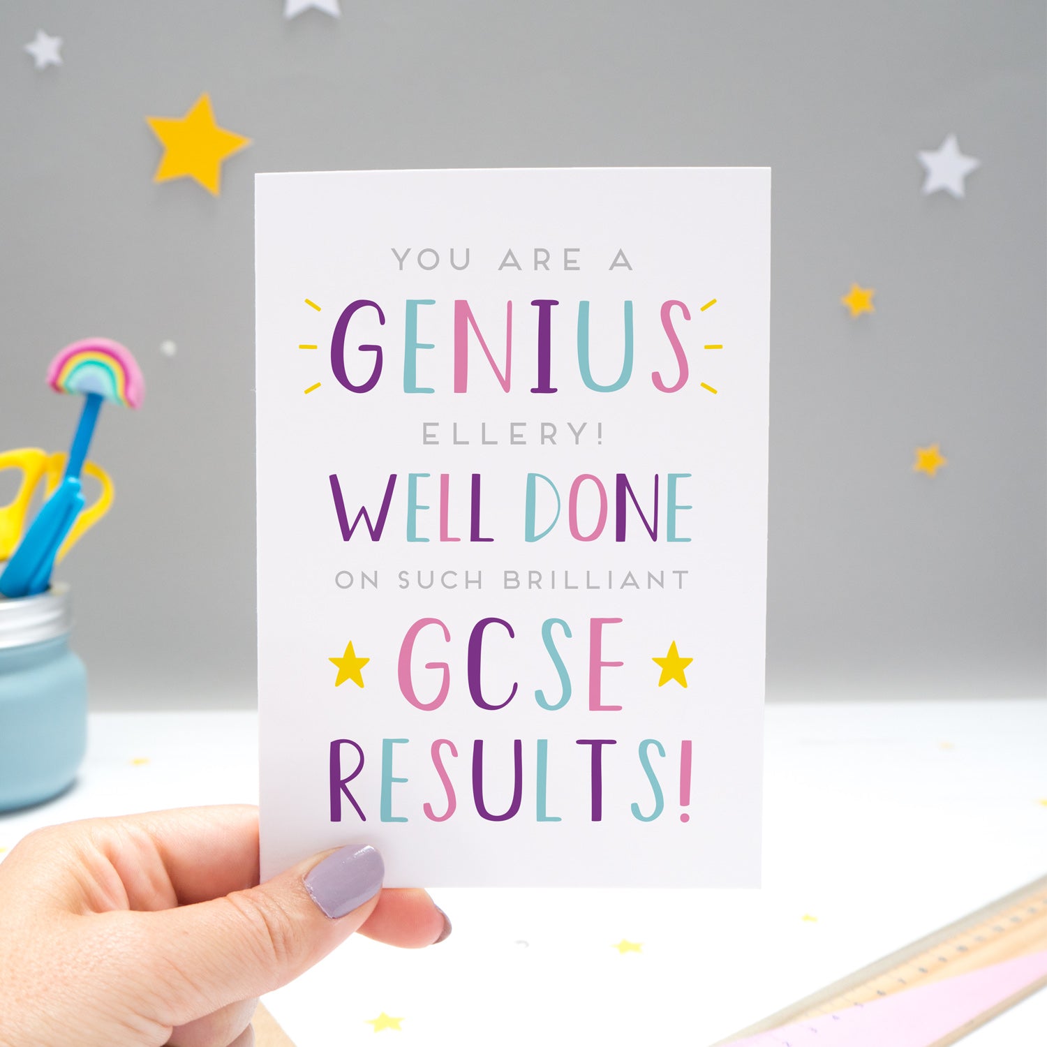 'You are a genius [insert name]! Well done on such brilliant GCSE results'. A personalised exam congratulations card featuring my hand drawn letters in varying shades of pink, purple and blue, and yellow stars.