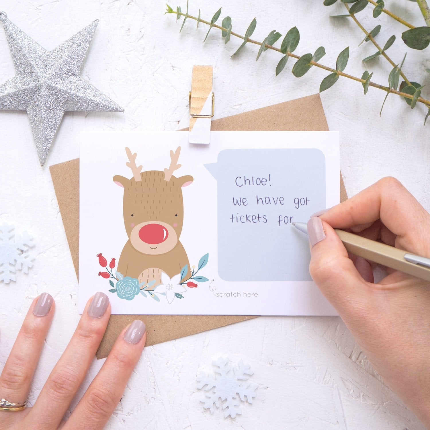Personalised reindeer secret message Christmas scratch card being hand written.