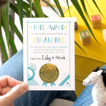A Grandpa certificate award card printed onto white card in varying tones of blue and pops of yellow! Each card features a shiny gold seal to make it official!