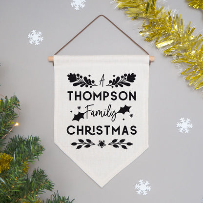 A personalised family Christmas banner flag personalised with your family name and adorned with festive flourishes! Each flag has a black print on natural coloured linen.