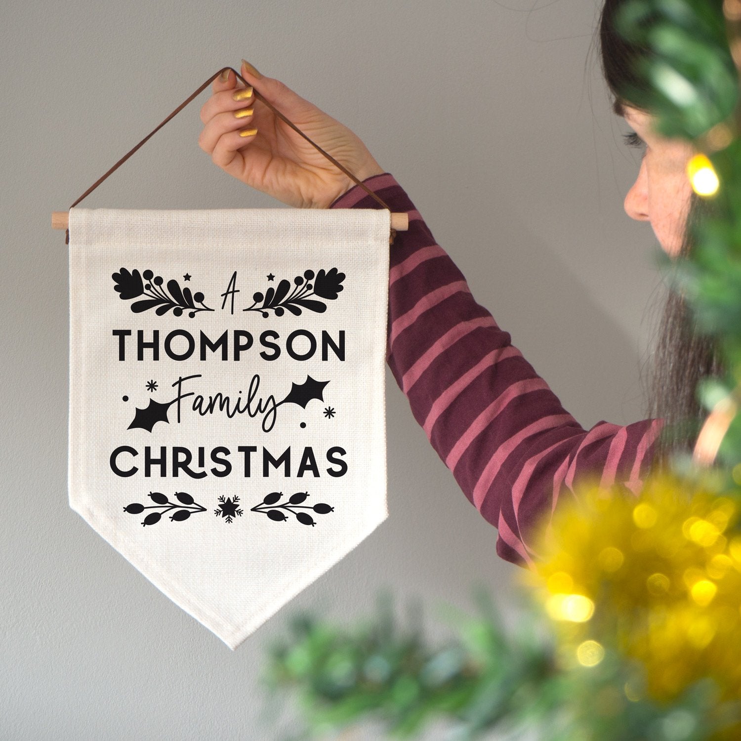 A personalised family Christmas banner flag personalised with your family name and adorned with festive flourishes! Each flag has a black print on natural coloured linen.