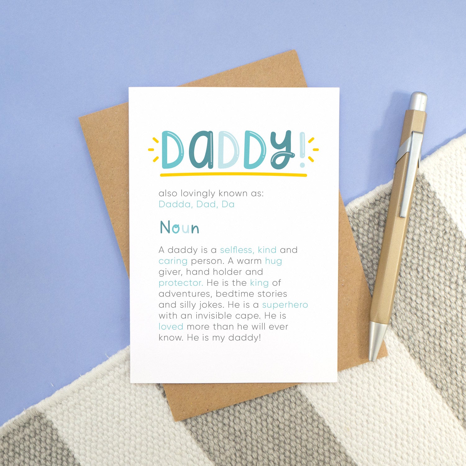A daddy definition card laying on a stripy carpet and a blue background. The card shows daddy in bold lettering with the personalised nicknames underneath, followed by the definition.