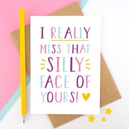 I really miss that silly face of yours card in pink, purple and blue, shot on a pink background with a yellow pencil.