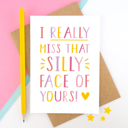 I really miss that silly face of yours card in pink, yellow and lilac shot on a pink background with a yellow pencil.