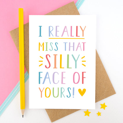 I really miss that silly face of yours card in rainbow, shot on a pink background with a yellow pencil.