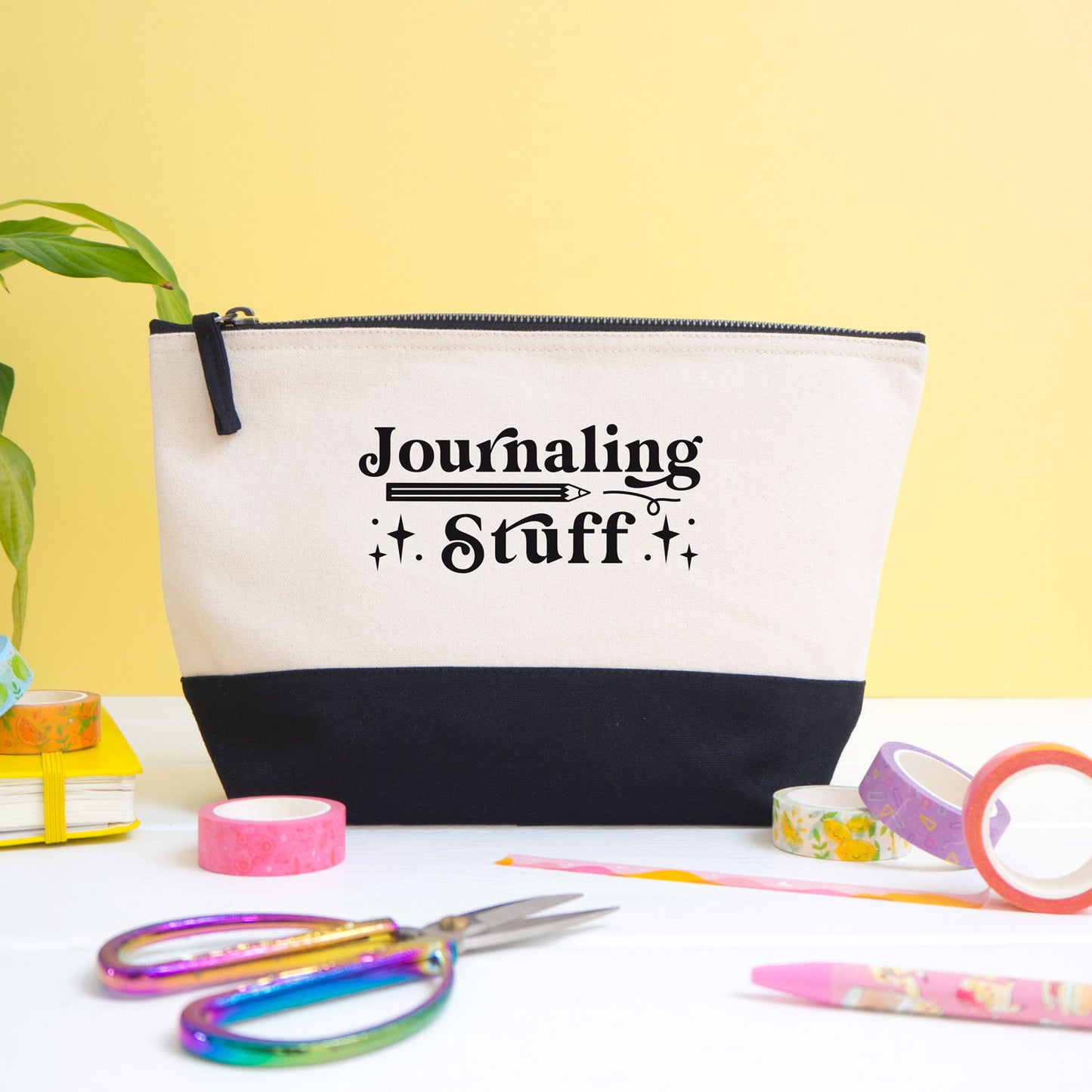 A journaling stuff project bag shot on a white and yellow background with journaling materials in the foreground.