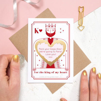 A custom king of hearts scratch card shot on a pink and white background with a scratched off heart.