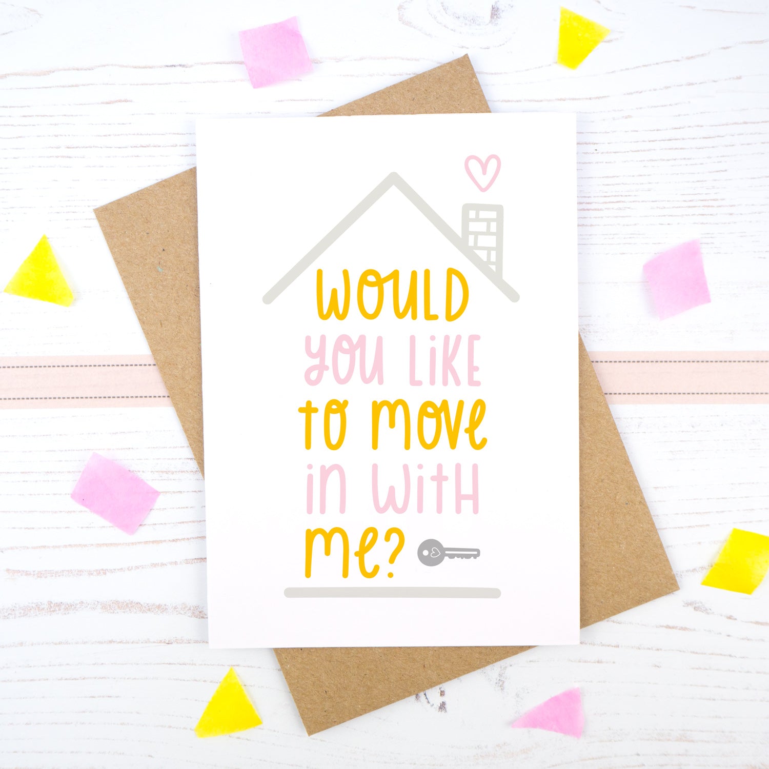 Would you like to move in with me card in pink and orange, under a grey roof and a dark grey key.