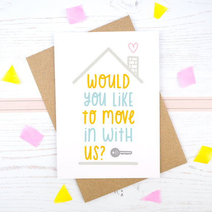 Would you like to move in with us card in blue and orange, under a grey roof and a dark grey key.