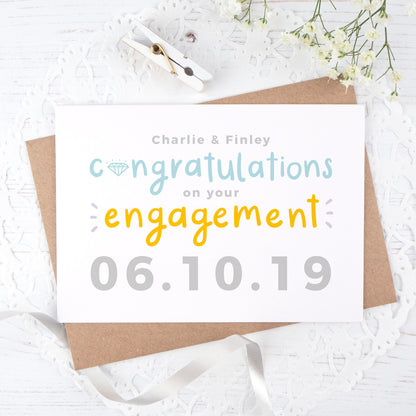 A personalised engagement card with room for the happy couples names and date the question was popped! This card has orange and blue text on a white background with a grey date.