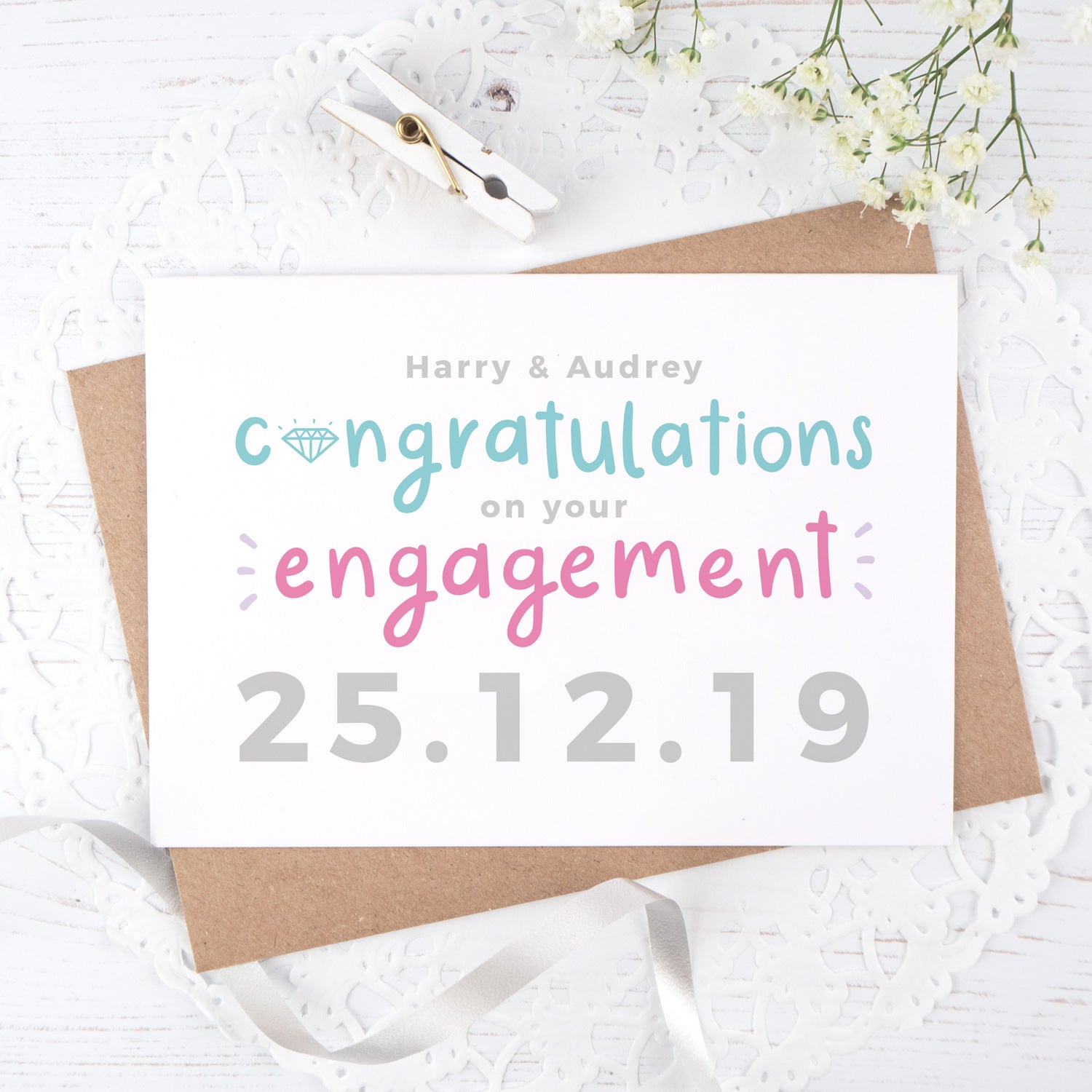 A personalised engagement card with room for the happy couples names and date the question was popped! This card has teal and pink text on a white background with a grey date.