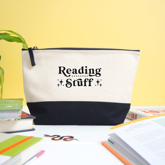 A reading stuff project bag shot on a white and yellow background with a variety of books in the foreground.