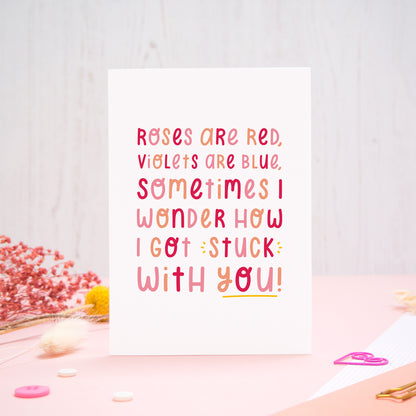 The 'stuck with you' card photographed standing up against an off white background with flowers, buttons and paperclips at the base of the card.