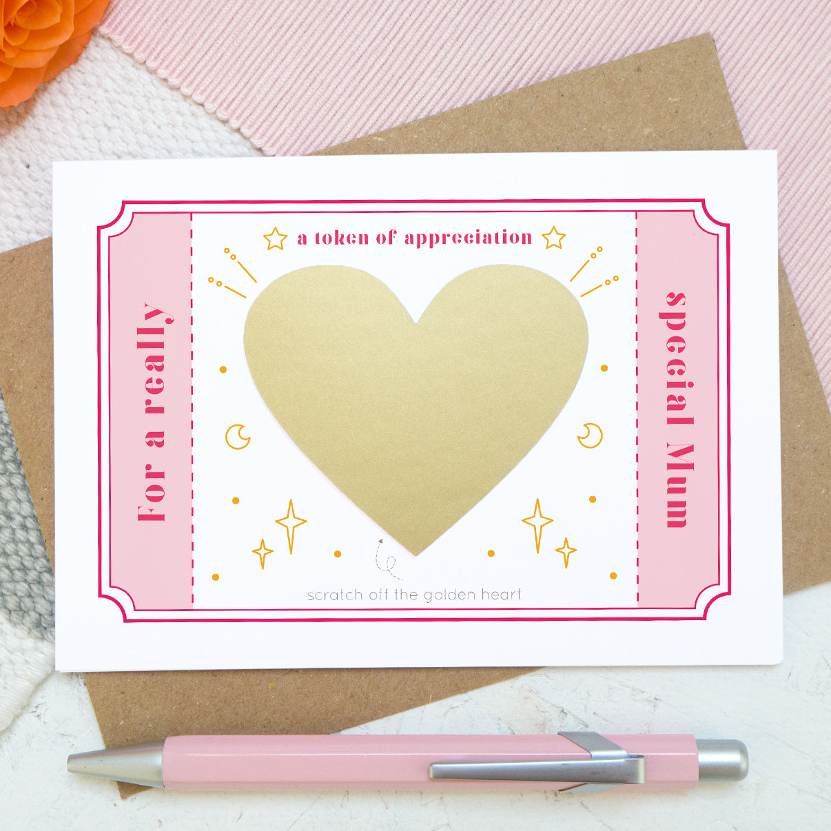 A token of appreciation scratch card by Joanne Hawker featuring a pink token and the words 'for a really special mum'. In the centre is a gold heart before it is scratched off to reveal the message.