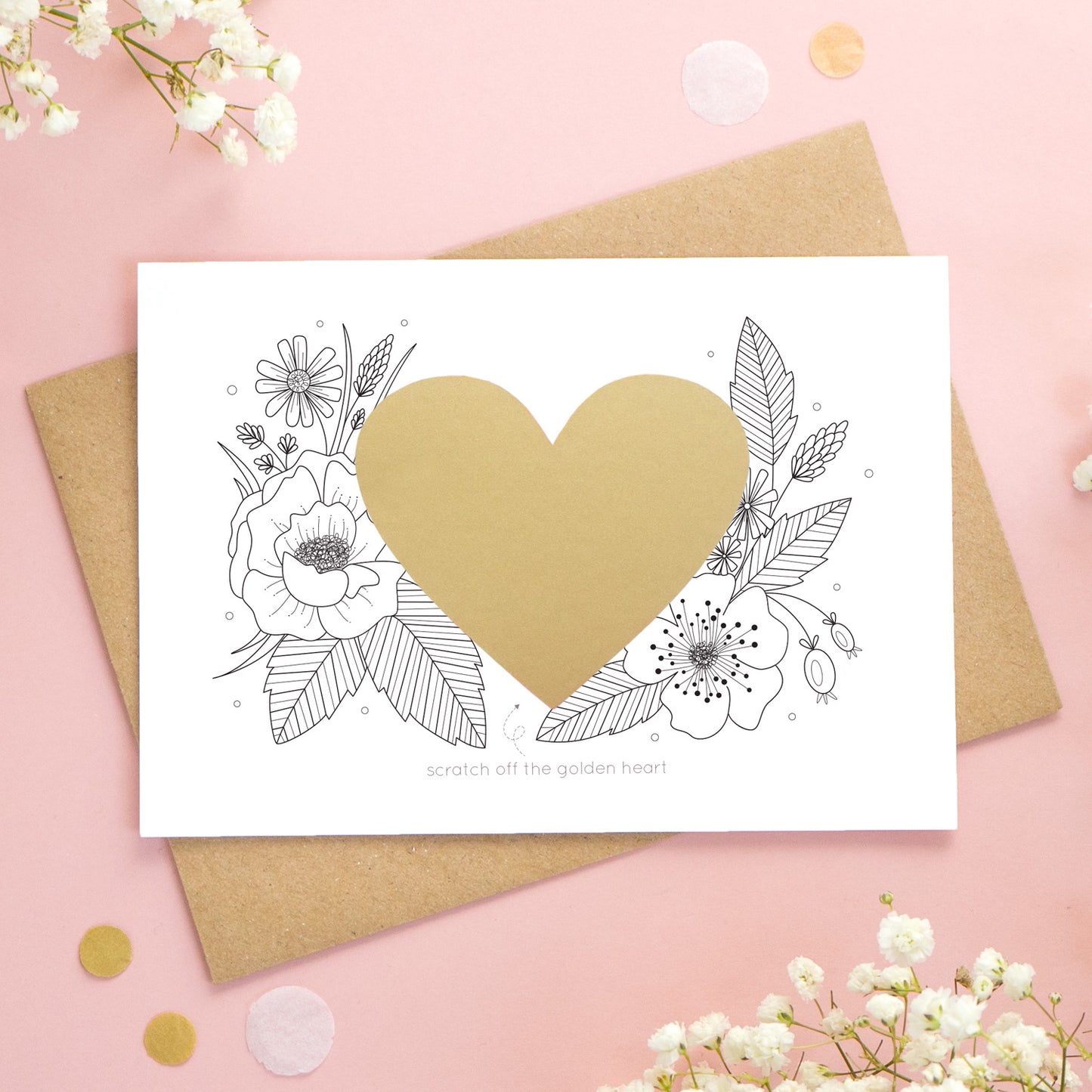 A personalised wedding scratch card shot on a pink background with white flowers. The golden heart is unscratched showing how the card will arrive.