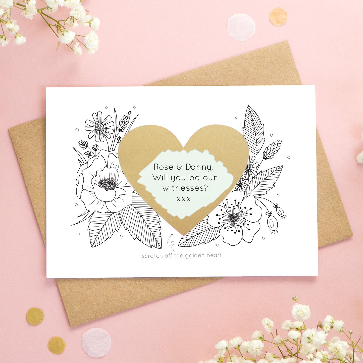 A personalised wedding scratch card shot on a pink background with white flowers. The golden heart has been scratched revealing a green heart and a witness proposal!