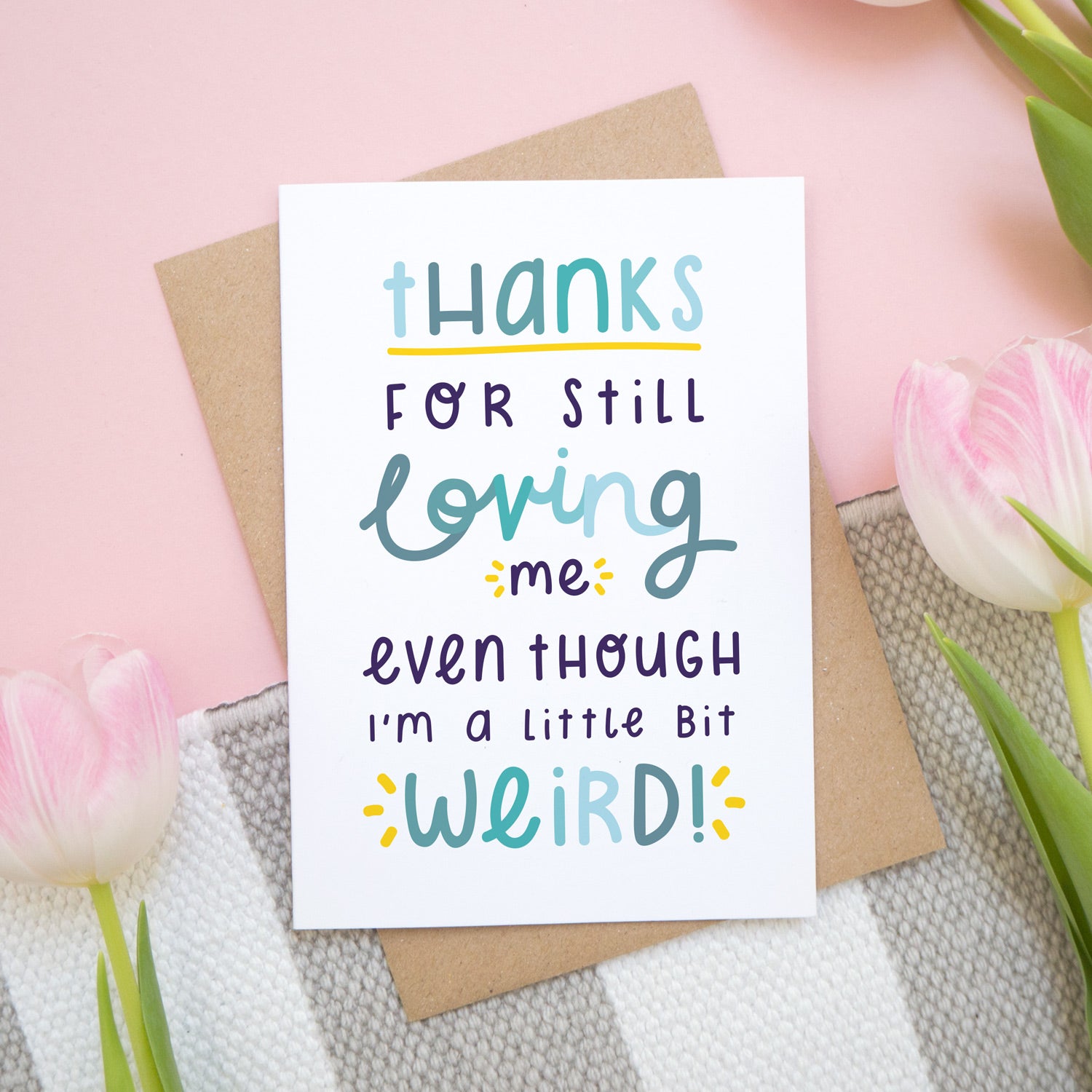 Thanks for still loving me even though I'm a little bit weird card in blue show on a pink background with tulips.