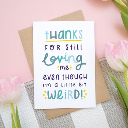Thanks for still loving me even though I'm a little bit weird card in blue show on a pink background with tulips.