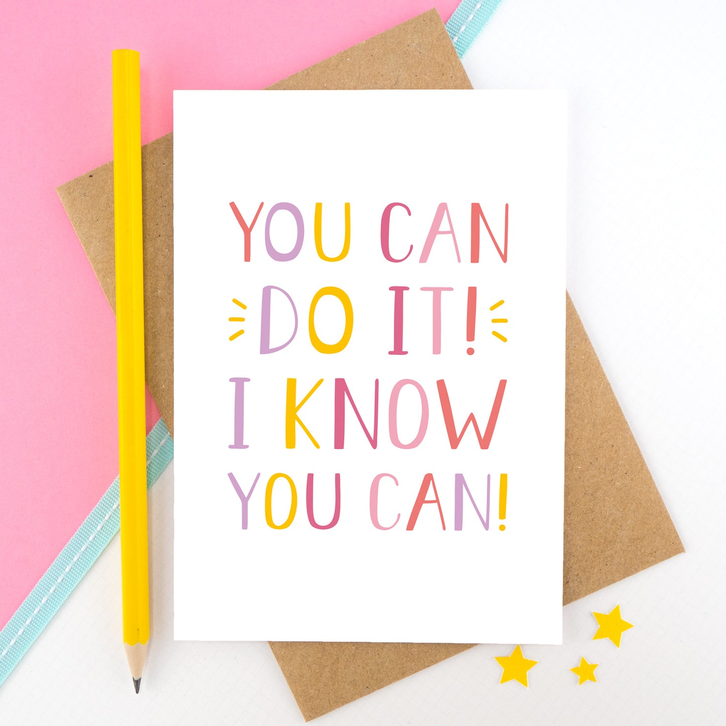 You can do it, I know you can! - Positive encouragement card photographed on a pick and white background separated with a teal ribbon. Also featuring a yellow pencil for scale. This version is in pink, yellow and lilac colour palette.